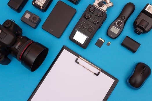 Top View of Photographer's, Videographer's or Blogger's Workplace. Digital Gadgets Lying on Blue Table - Flat Lay photo