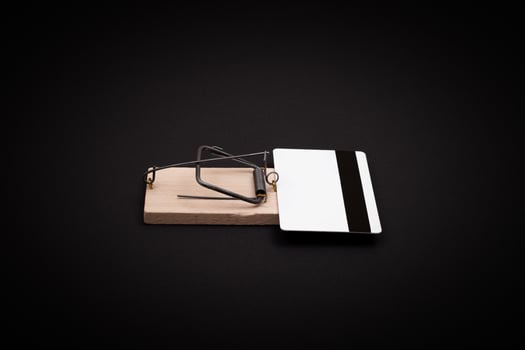 Credit Risk and Loan Trap - White Blank Credit Card Template in Wooden Mouse Trap on Black Background photo