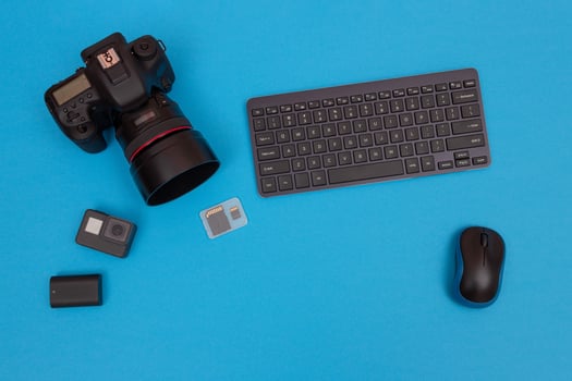 Top View of Photographer's, Videographer's or Blogger's Workplace. Digital Gadgets Lying on Blue Table - Flat Lay photo