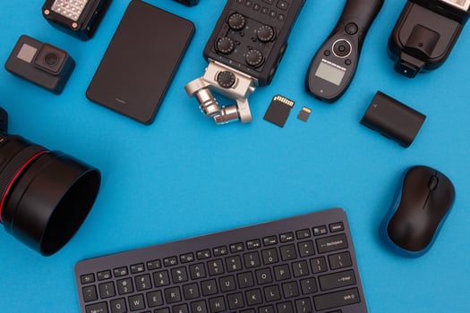 Top View of Photographer's, Videographer's or Blogger's Workplace. Digital Gadgets Lying on Blue Table - Flat Lay photo