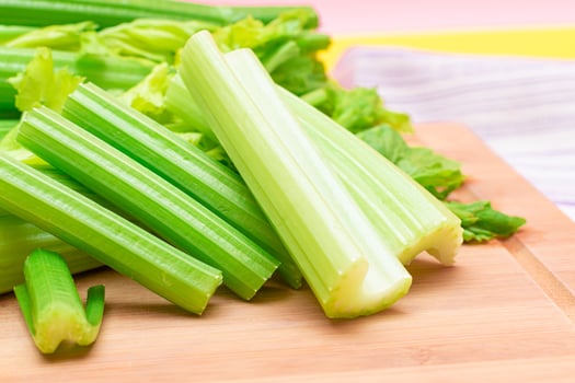 Fresh Celery Stem and Chopped Celery Sticks on Wooden Cutting Board. Vegan and Vegetarian Culture. Raw Food. Healthy Diet with Negative Calorie Content. Slimming Food photo