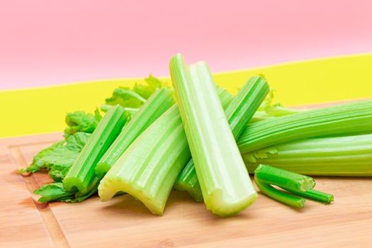 Fresh Celery Stem and Chopped Celery Sticks on Wooden Cutting Board. Vegan and Vegetarian Culture. Raw Food. Healthy Diet with Negative Calorie Content. Slimming Food photo