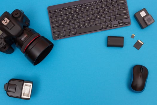 Top View of Photographer's, Videographer's or Blogger's Workplace. Digital Gadgets Lying on Blue Table - Flat Lay photo