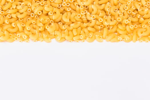 Uncooked Chifferi Rigati Pasta Scattered on White Table. Fat and Unhealthy Food. Classic Dry Macaroni. Italian Culture and Cuisine. Raw Pasta photo