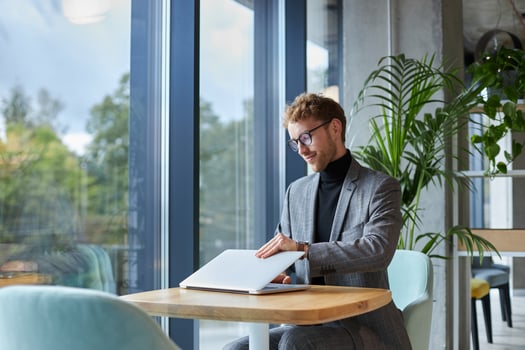 Businessman closing laptop after finishing work in cafe photo