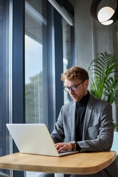 Focused businessman working on laptop in modern office photo