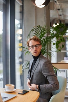 Businessman buttoning his jacket in a cafe photo