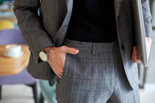 Businessman standing with hand in pocket holding laptop photo