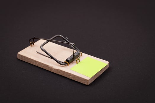 Blank Yellow Sheet of Paper in Wooden Mousetrap - Template. Small Memo Paper in Mouse Trap on Black Background photo