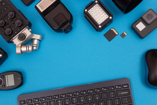Top View of Photographer's, Videographer's or Blogger's Workplace. Digital Gadgets Lying on Blue Table - Flat Lay photo