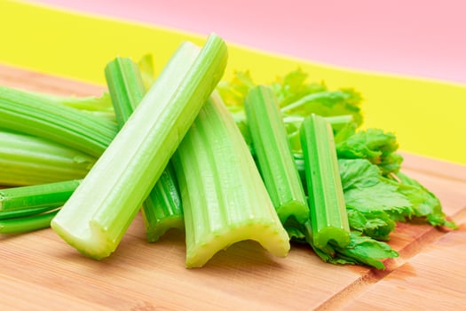 Fresh Celery Stem and Chopped Celery Sticks on Wooden Cutting Board. Vegan and Vegetarian Culture. Raw Food. Healthy Diet with Negative Calorie Content. Slimming Food photo