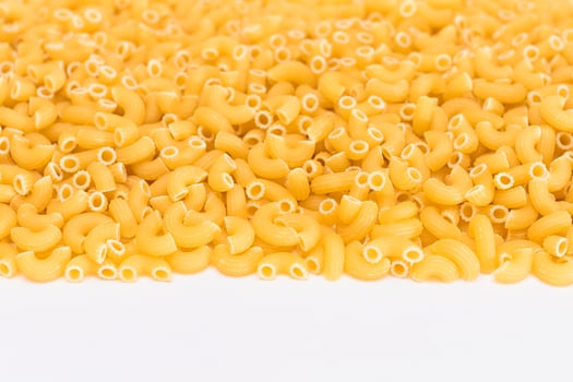 Uncooked Chifferi Rigati Pasta Scattered on White Table. Fat and Unhealthy Food. Classic Dry Macaroni. Italian Culture and Cuisine. Raw Pasta photo