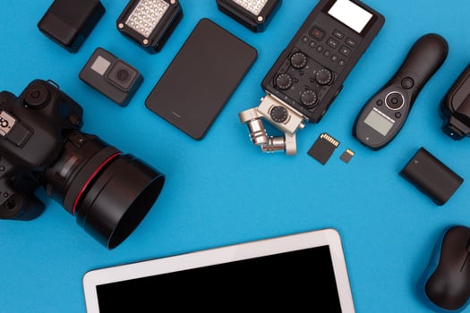 Top View of Photographer's, Videographer's or Blogger's Workplace. Digital Gadgets Lying on Blue Table - Flat Lay photo