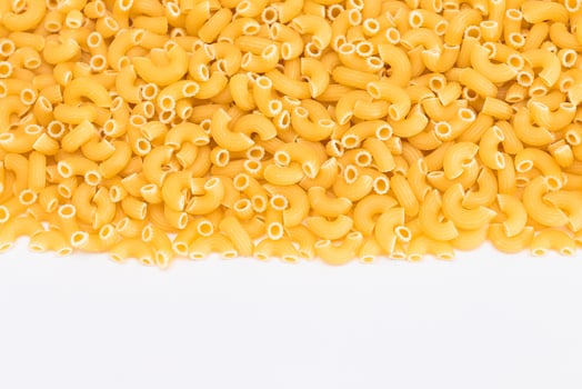 Uncooked Chifferi Rigati Pasta Scattered on White Table. Fat and Unhealthy Food. Classic Dry Macaroni. Italian Culture and Cuisine. Raw Pasta photo