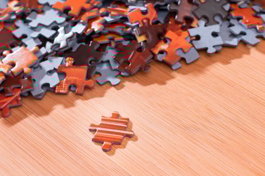 Colorful Pieces of a Mixed Jigsaw Puzzle Lie on the Wooden Table - Strategy and Solving Problem Concept photo