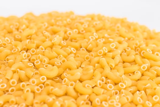 A Heap of Uncooked Chifferi Rigati Pasta on White Background. Fat and Unhealthy Food. Classic Dry Macaroni Texture. Italian Culture and Cuisine. Raw Pasta photo