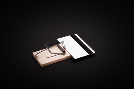 Credit Risk and Loan Trap - White Blank Credit Card Template in Wooden Mouse Trap on Black Background photo
