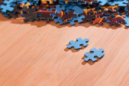 Colorful Pieces of a Mixed Jigsaw Puzzle Lie on the Wooden Table - Strategy and Solving Problem Concept photo