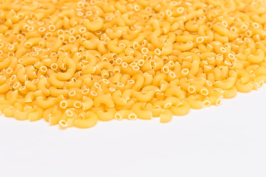 A Heap of Uncooked Chifferi Rigati Pasta on White Background. Fat and Unhealthy Food. Classic Dry Macaroni Texture. Italian Culture and Cuisine. Raw Pasta photo