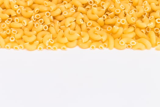Uncooked Chifferi Rigati Pasta Scattered on White Table. Fat and Unhealthy Food. Classic Dry Macaroni. Italian Culture and Cuisine. Raw Pasta photo