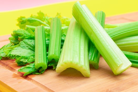 Fresh Celery Stem and Chopped Celery Sticks on Wooden Cutting Board. Vegan and Vegetarian Culture. Raw Food. Healthy Diet with Negative Calorie Content. Slimming Food photo