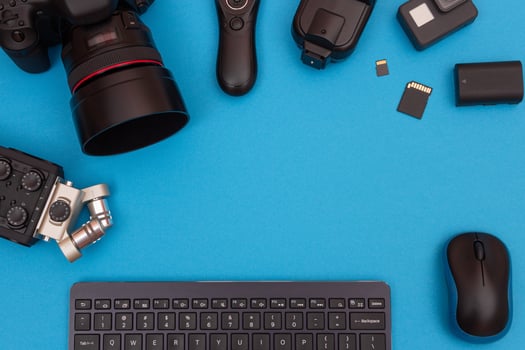 Top View of Photographer's, Videographer's or Blogger's Workplace. Digital Gadgets Lying on Blue Table - Flat Lay photo