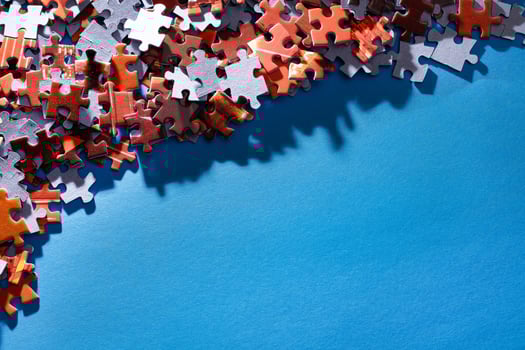 Mixed Pieces of a Colorful Jigsaw Puzzle Lie on the Blue Background With Copy Space - Strategy and Solving Problem Concept photo