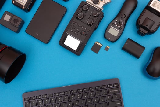 Top View of Photographer's, Videographer's or Blogger's Workplace. Digital Gadgets Lying on Blue Table - Flat Lay photo