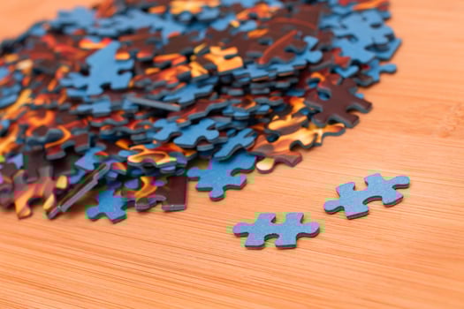 Colorful Pieces of a Mixed Jigsaw Puzzle Lie on the Wooden Table - Strategy and Solving Problem Concept photo