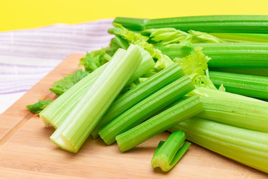 Fresh Celery Stem and Chopped Celery Sticks on Wooden Cutting Board. Vegan and Vegetarian Culture. Raw Food. Healthy Diet with Negative Calorie Content. Slimming Food photo
