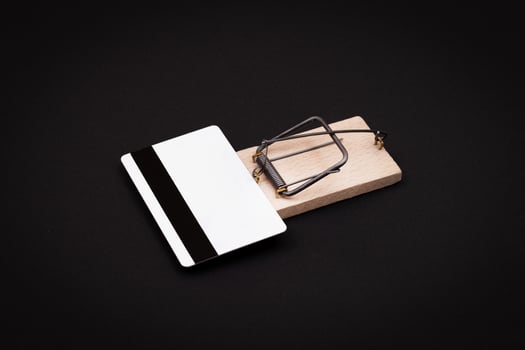 Credit Risk and Loan Trap - White Blank Credit Card Template in Wooden Mouse Trap on Black Background photo
