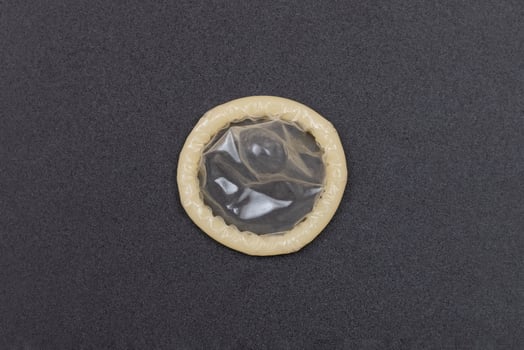 Unpacked Latex Condom On Black Background photo
