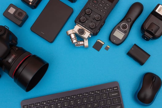 Top View of Photographer's, Videographer's or Blogger's Workplace. Digital Gadgets Lying on Blue Table - Flat Lay photo