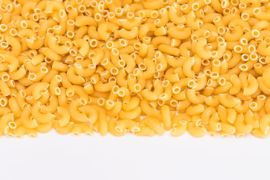 Uncooked Chifferi Rigati Pasta Scattered on White Table. Fat and Unhealthy Food. Classic Dry Macaroni. Italian Culture and Cuisine. Raw Pasta photo