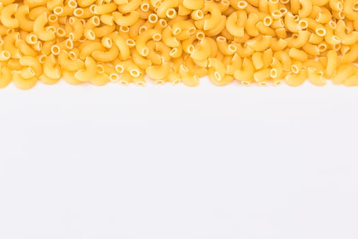 Uncooked Chifferi Rigati Pasta Scattered on White Table. Fat and Unhealthy Food. Classic Dry Macaroni. Italian Culture and Cuisine. Raw Pasta photo