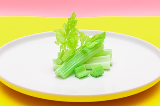 Fresh Chopped Celery Sticks and Slices with Water Drops on White Dish. Vegan and Vegetarian Culture. Raw Food. Healthy Diet with Negative Calorie Content photo