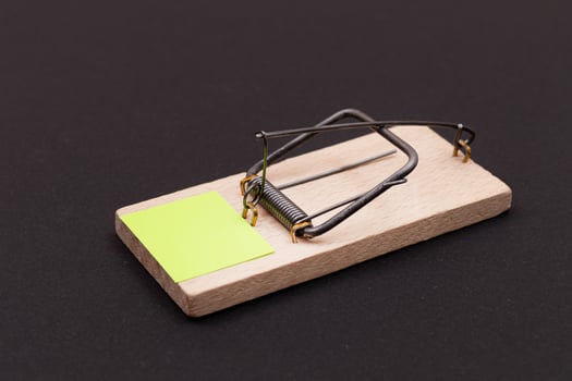 Blank Yellow Sheet of Paper in Wooden Mousetrap - Template. Small Memo Paper in Mouse Trap on Black Background photo