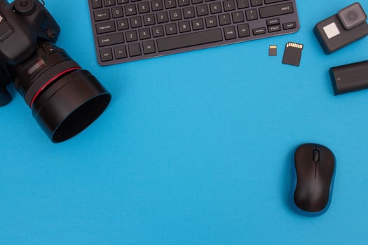 Top View of Photographer's, Videographer's or Blogger's Workplace. Digital Gadgets Lying on Blue Table - Flat Lay photo