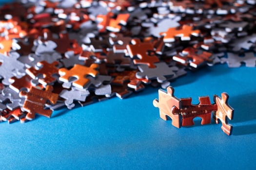 Mixed Pieces of a Colorful Jigsaw Puzzle Lie on the Blue Background - Strategy and Solving Problem Concept photo