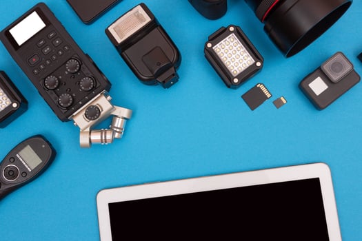 Top View of Photographer's, Videographer's or Blogger's Workplace. Digital Gadgets Lying on Blue Table - Flat Lay photo