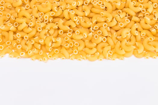Uncooked Chifferi Rigati Pasta Scattered on White Table. Fat and Unhealthy Food. Classic Dry Macaroni. Italian Culture and Cuisine. Raw Pasta photo