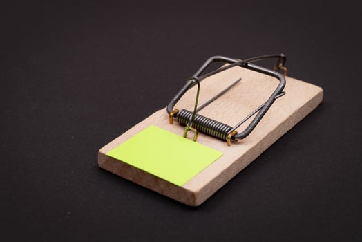 Blank Yellow Sheet of Paper in Wooden Mousetrap - Template. Small Memo Paper in Mouse Trap on Black Background photo