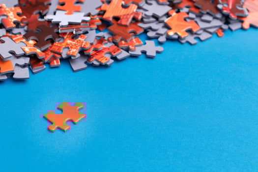 Mixed Pieces of a Colorful Jigsaw Puzzle Lie on the Blue Background With Copy Space - Strategy and Solving Problem Concept photo