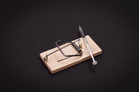 Drug Addict, Heroin Hazard or Dose Trap Concept - Disposable Insulin Syringe with Drug Dose Inside Lying in Wooden Mousetrap on Black Background photo