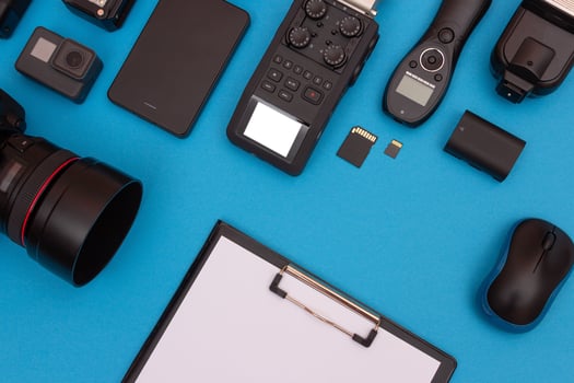 Top View of Photographer's, Videographer's or Blogger's Workplace. Digital Gadgets Lying on Blue Table - Flat Lay photo