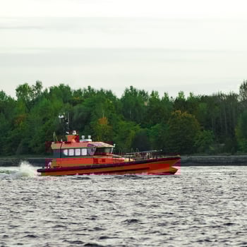 Orange pilot ship sailing on the Daugava river photo