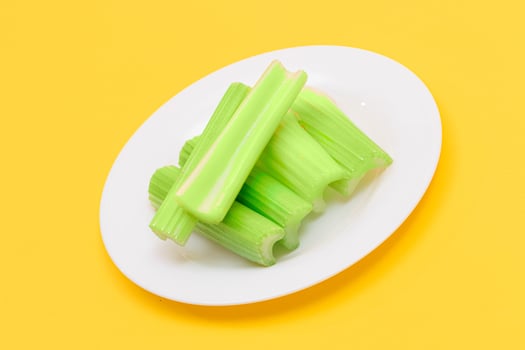 Fresh Chopped Celery Sticks on White Dish. Vegan and Vegetarian Culture. Raw Food. Healthy Diet with Negative Calorie Content photo