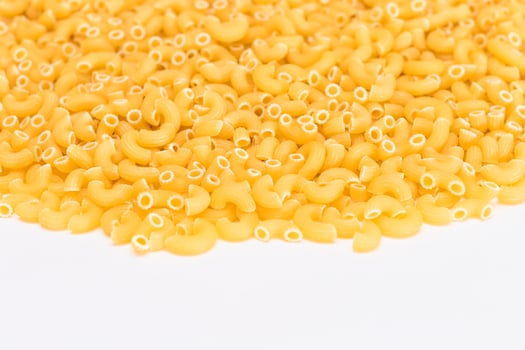 A Heap of Uncooked Chifferi Rigati Pasta on White Background. Fat and Unhealthy Food. Classic Dry Macaroni Texture. Italian Culture and Cuisine. Raw Pasta photo