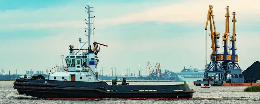 Black tug ship moving to the cargo terminal. Industrial service photo