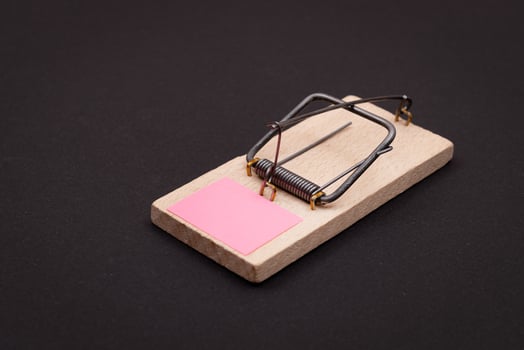 Blank Pink Sheet of Paper in Wooden Mousetrap - Template. Small Memo Paper in Mouse Trap on Black Background photo